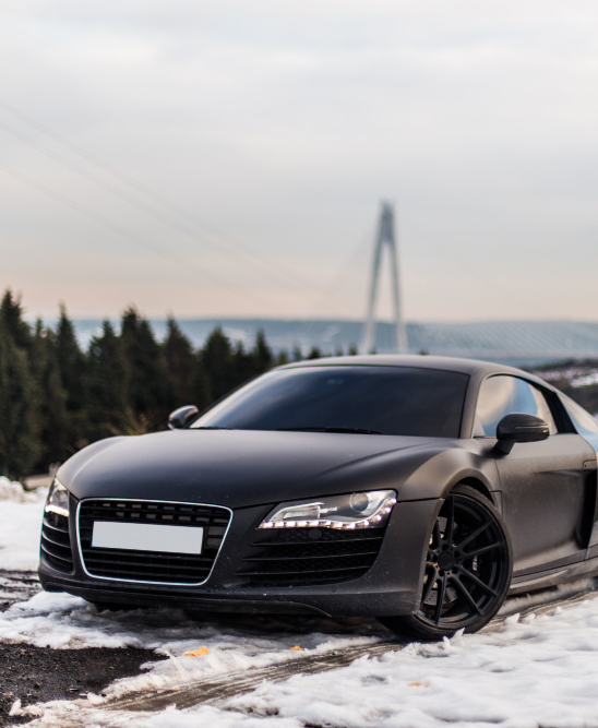 luxury-black-sport-coupe-parking-snowy-road-forest